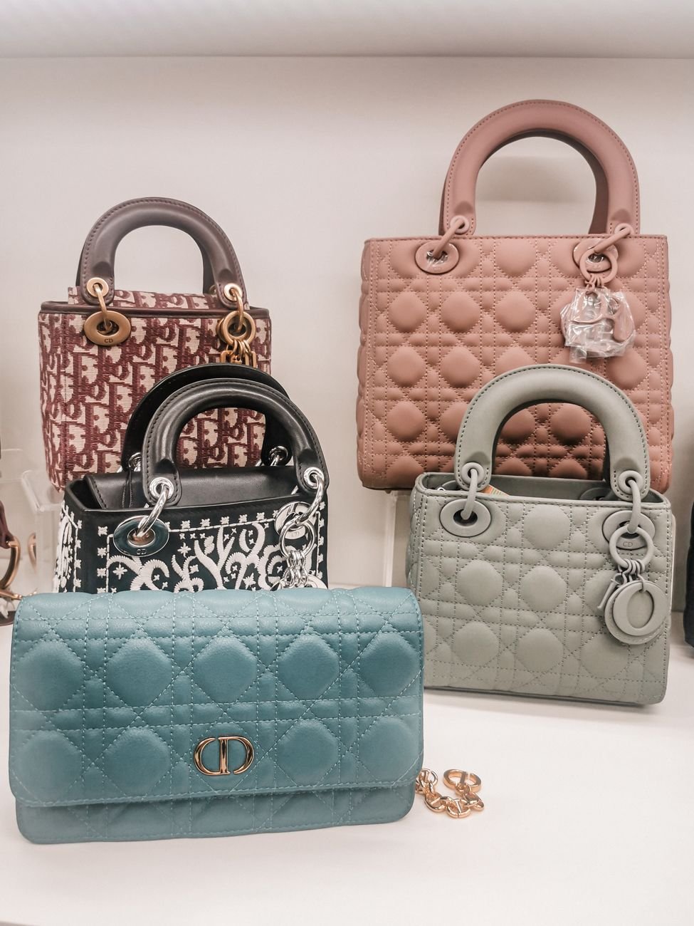 A stylish arrangement of luxury handbags on a white surface, showcasing elegance and design.