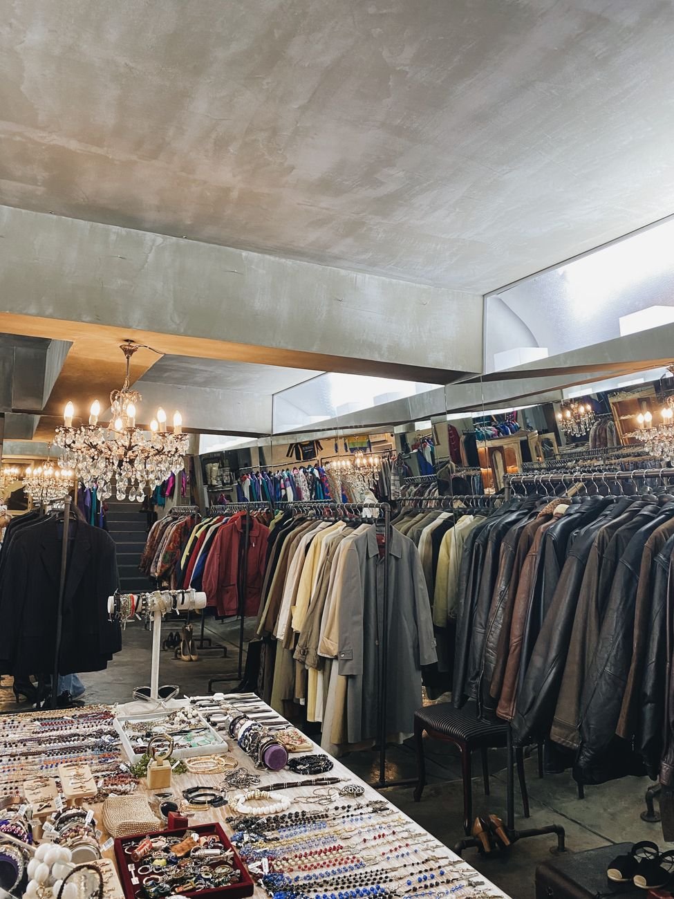 Charming vintage clothing store interior with elegant chandeliers and racks of colorful garments.